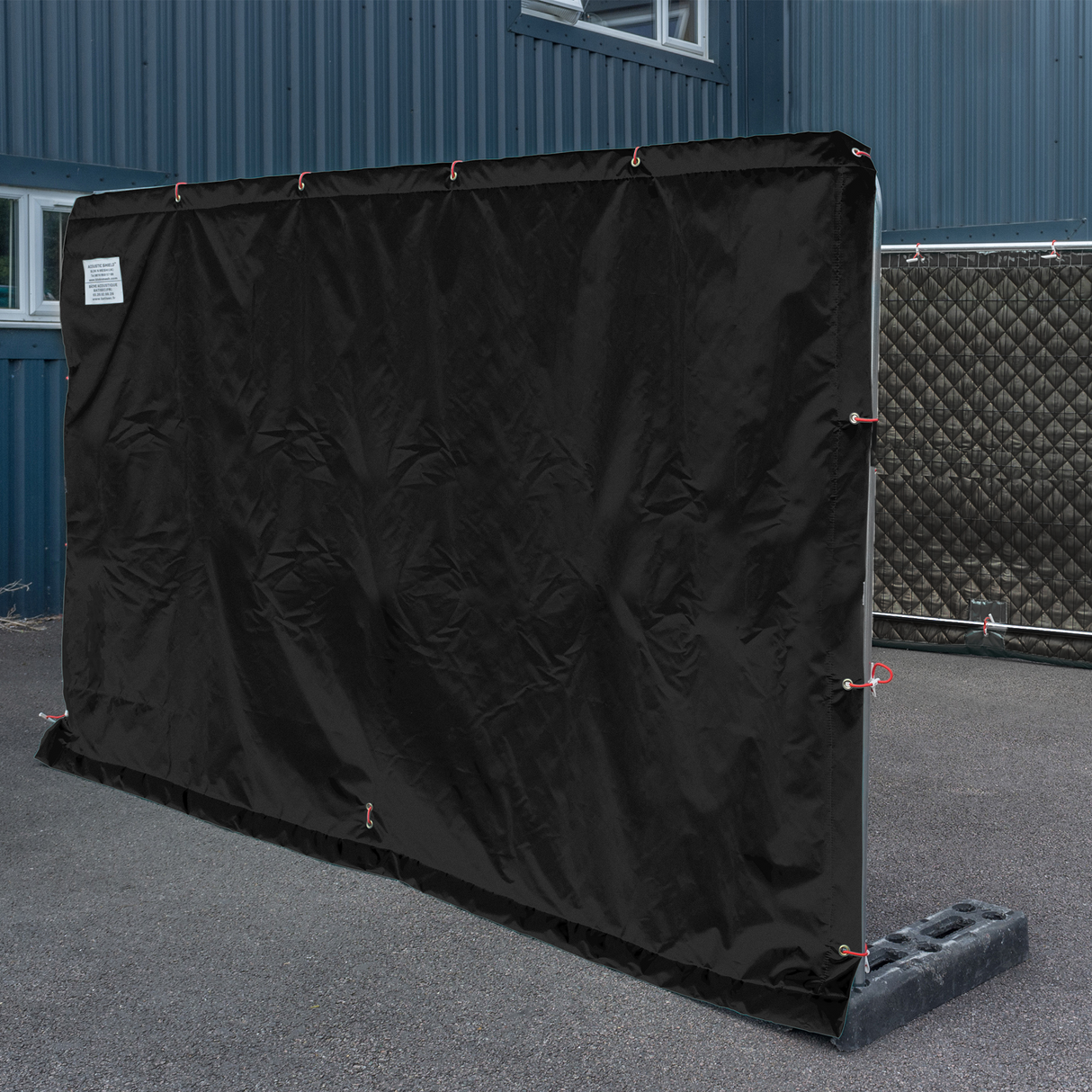Acoustic shield attached to a temporary fence panel