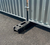 14 kg plastic block holding a construction fence, used for stabilizing temporary barriers
