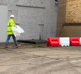 Person connecting multiple traffic separators, demonstrating assembly and setup